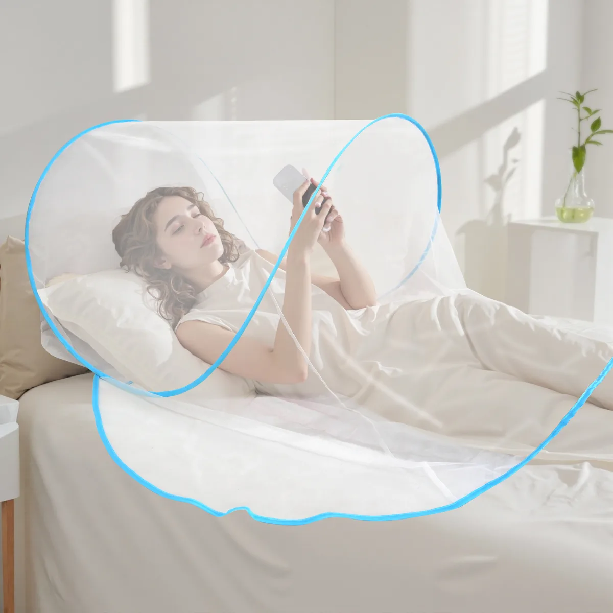 Moustiquaire de tête bleue sur un oreiller, une femme lit au lit