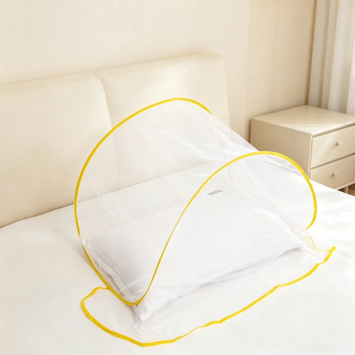 Moustiquaire de tête jaune dépliée sur un oreiller