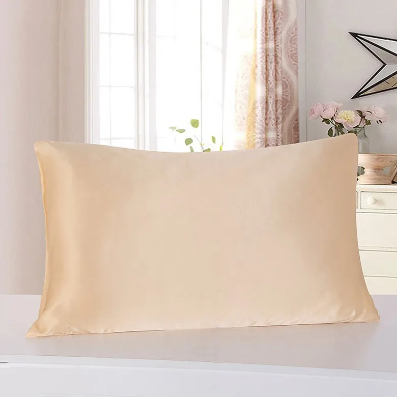Taie d’oreiller en satin beige sur un oreiller, dans une chambre