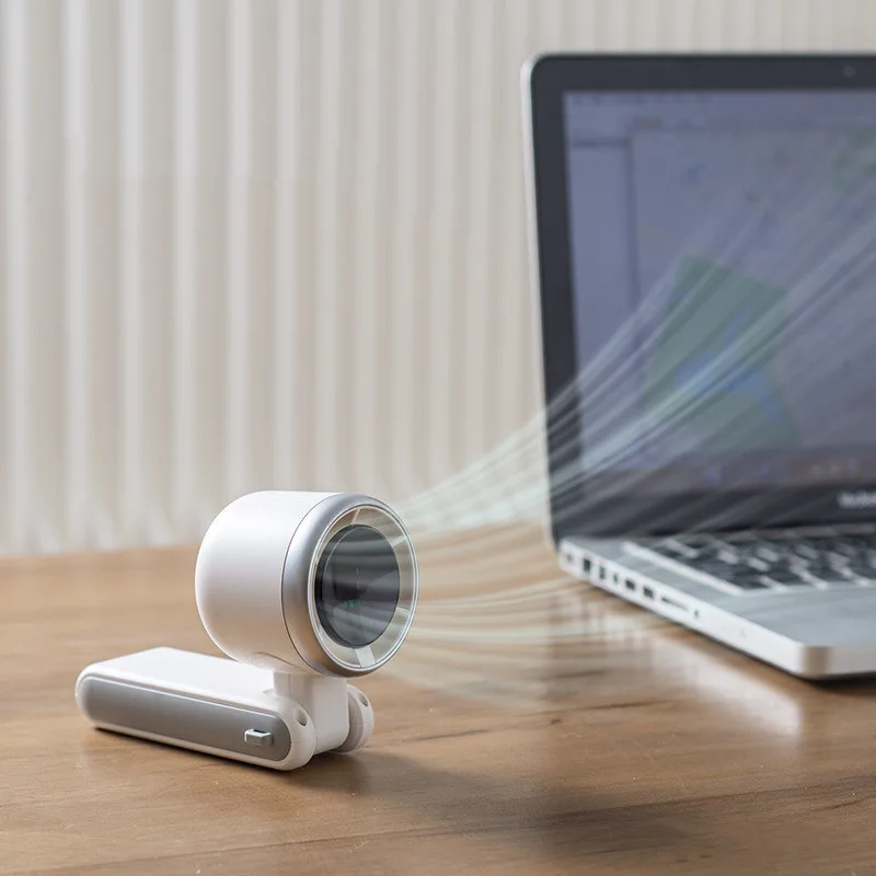 Ventilateur turbo pliant posé sur un bureau, orienté vers l’utilisateur devant un ordinateur portable
